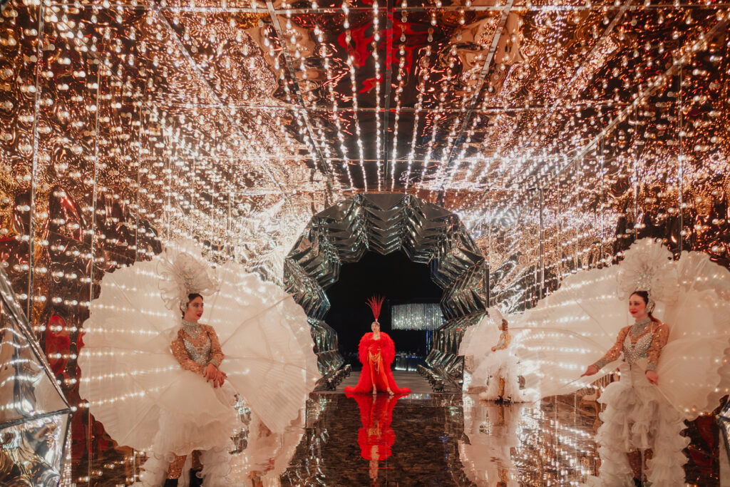 Dancers with white feather fans in a mirrored light tunnel at Aashav and Janvi's sangeet