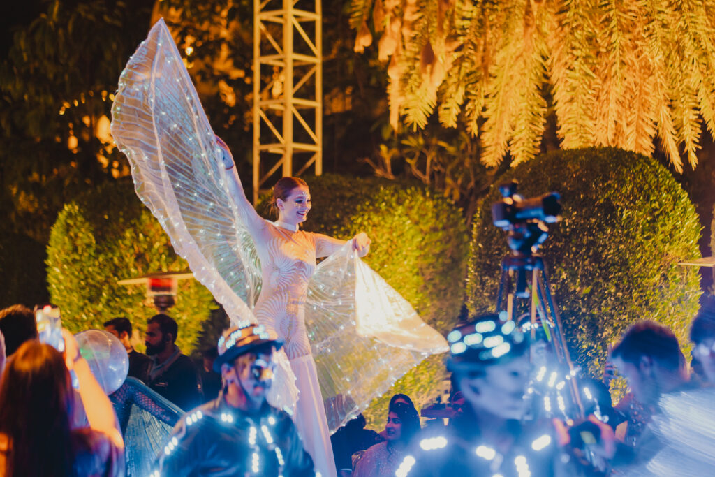 Performer with illuminated wings at Shubham and Sumegha's sangeet