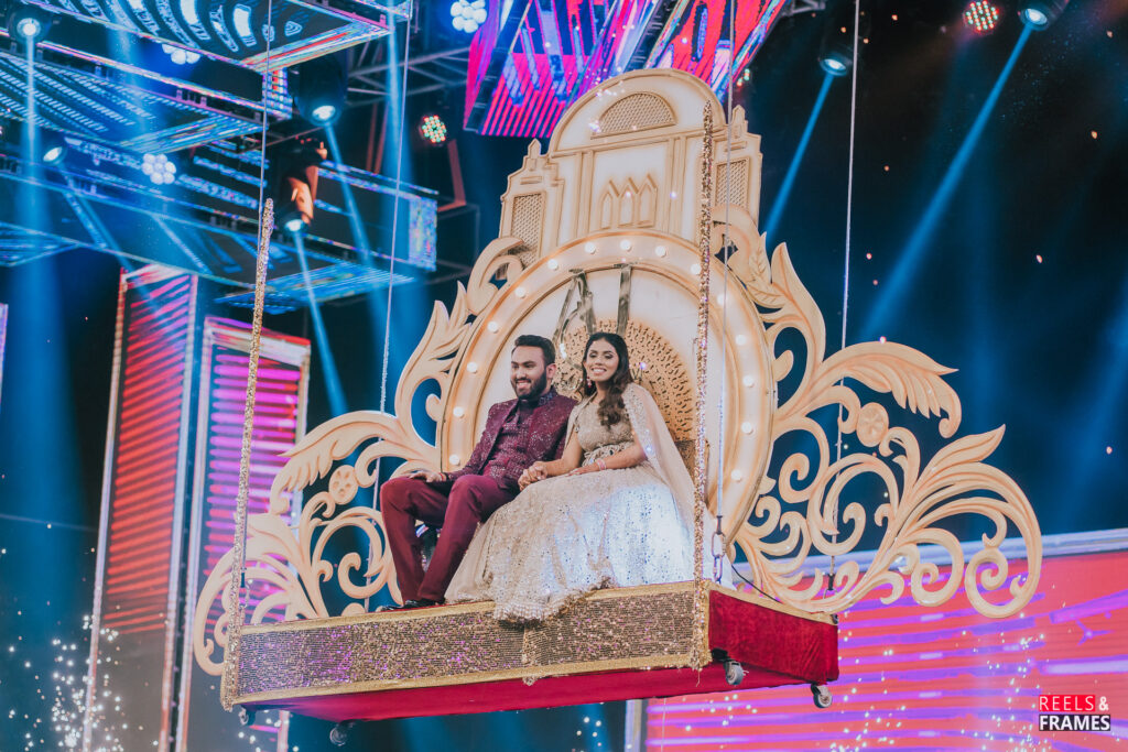Aashav and Janvi's engagement entry on an ornate suspended swing